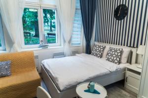 una camera con letto, sedia e finestre di Marina House Apartments a Międzyzdroje