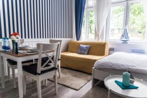 a bedroom with a bed and a desk and a table at Marina House Apartments in Międzyzdroje +58 photos