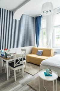 a living room with a bed and a dining room at Marina House Apartments in Międzyzdroje