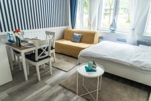 a bedroom with a bed and a table and a chair at Marina House Apartments in Międzyzdroje