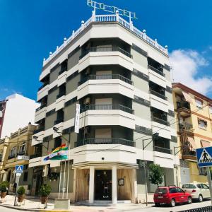 a tall white building on the corner of a street at Hotel Fernando IV in Martos