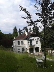 Uma casa branca com um banco à frente. em Villa Eisenwerk em Wilhelmsburg