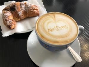 a cup of coffee and a pastry on a table at Dimora Nettare in Brindisi