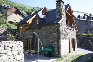 a stone house with a table in front of it at la grange avec spa in Saint-Aventin