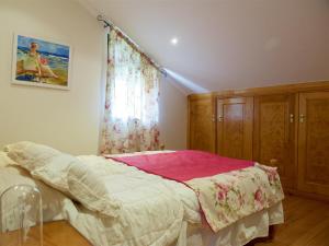 a bedroom with a bed with a pink blanket and a window at Vivienda de uso turístico Eido de Roque in Mondariz