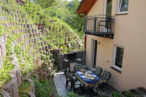 un patio al aire libre con mesa, sillas y plantas en Ferienhaus Trimmisch, en Ediger-Eller