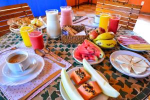 a table topped with plates of food and drinks at Pousada Ana Terra in Monte Verde
