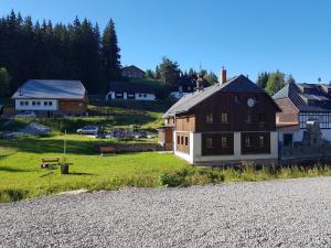 a house on the side of a gravel road at Penzion Pupík in Modrava
