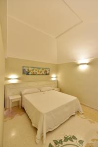 a bedroom with a white bed and a painting on the wall at Fortino San Giorgio in Gallipoli