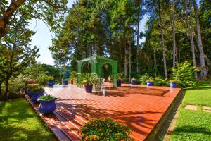 a garden with a gate and potted plants and trees at Pousada Ana Terra in Monte Verde