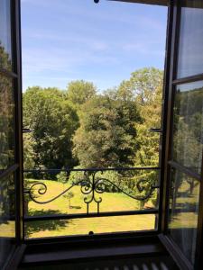 una ventana abierta con vistas a un parque en A l'Aube des Volcans, en Charbonnières-les-Vieilles
