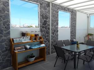 a dining room with a table and two windows at Azalea Hotel in Kamari