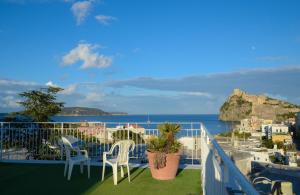 a balcony with chairs and a view of the ocean at Hotel Europa in Ischia