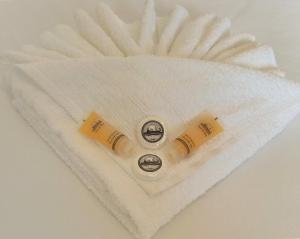 2 rouleaux de serviettes blanches sur une table blanche dans l'établissement Finikas Rooms, à Agia Marina