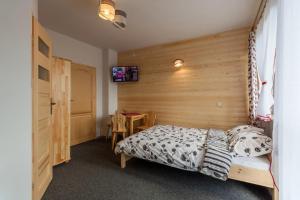 kwatery polaczyk في كروتشيينكو: غرفة نوم بسرير وجدار خشبي
