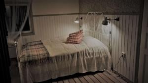 a bedroom with a white bed with a pillow on it at Vehmaanpirtti in Orivesi