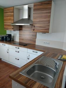 eine Küche mit einer Spüle aus Edelstahl und Arbeitsflächen aus Holz in der Unterkunft Ferienwohnung Sprockhövel in Sprockhövel