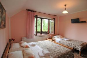 sypialnia z 2 łóżkami i oknem w obiekcie Plitvice Rooms Family Glumac w mieście Jeziora Plitwickie