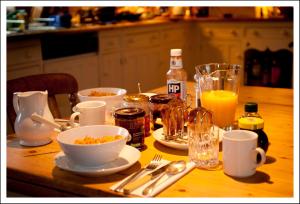 una mesa de madera con tazones de comida y bebida. en The Old Stables B&B, en Winslow