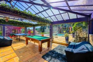 a room with a ping pong table and a glass ceiling at Pousada Ana Terra in Monte Verde +50 photos