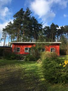 une maison rouge au milieu d'une cour dans l'établissement Küstenferienhaus Nr. 91/92, à Stahlbrode