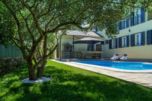 a yard with a pool and a tree and a house at Villa Lorena in Zaton