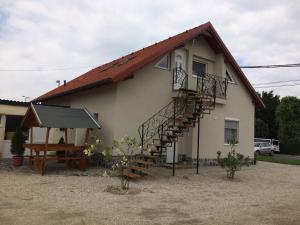 Una pequeña casa con una escalera en el lateral. en Báró Berg Apartman, en Kapuvár