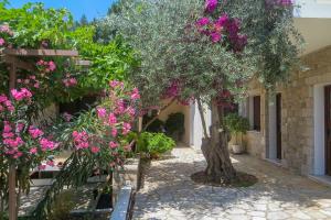 a tree with pink flowers in a courtyard at Kerveli Luxury Villa in Kerveli