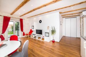 un soggiorno con tavolo e sedie rosse di Apartments Stinice a Gradac (Grado)