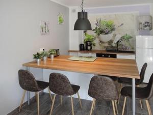 eine Küche mit einem Holztisch und 4 Stühlen in der Unterkunft Apartament Nr.9 in Pobierowo