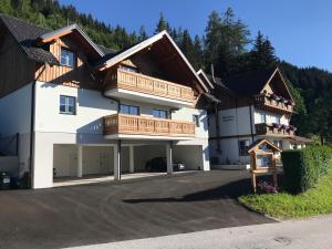 - un grand bâtiment blanc avec un balcon en bois dans l'établissement Ferienwohnung Hochstein, à Haus im Ennstal