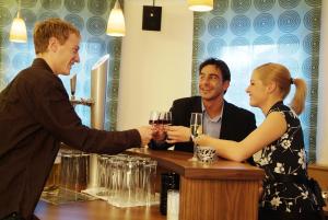 a man handing a woman a glass of wine at a bar at Astellina hotel-apart in Ischgl