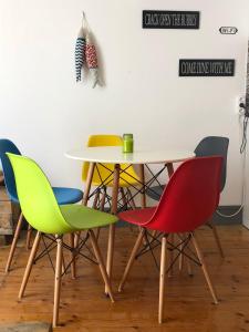 a table with four colorful chairs and a table and a table at Central Tavira apartment with balcony, Casa Cristina in Tavira