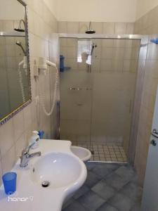 La salle de bains est pourvue d'une douche, d'un lavabo et de toilettes. dans l'établissement Bed and breakfast Delfino Blu, à Torre Vado