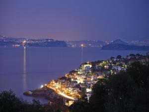 a town on an island in the water at night at Hotel Villa D'Orta in Ischia