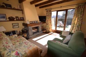ein Wohnzimmer mit einem Sofa und einem Kamin in der Unterkunft Casa en Bolvir, jardin y piscina in Bolvir
