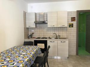 a kitchen with a table and chairs and a sink at Brigida's Apartments in Ipsos