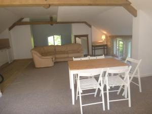 uma sala de estar com uma mesa e cadeiras e um sofá em Villa Rosa em Saint-Georges-sur-Cher