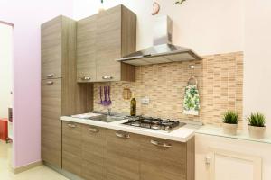 a kitchen with wooden cabinets and a stove top oven at Apartament Ciraulo in Catania