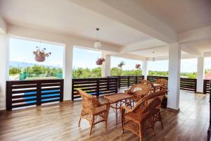 a dining room with tables and chairs and windows at Pensiunea Luminita in Târgu Jiu