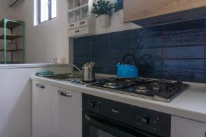 a kitchen with a stove with a blue tea kettle on it at Kartè in Belpasso
