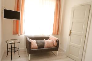 a living room with a chair and a window at Morzsi Apartman in Szilvásvárad