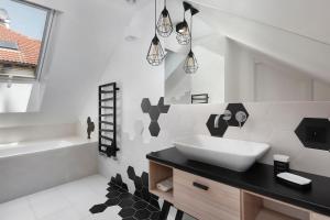a black and white bathroom with a sink and a tub at Aloza in Ustka