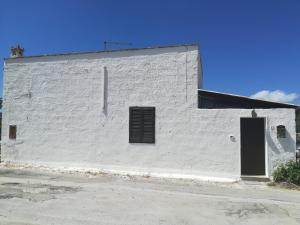un edificio bianco con una porta sul lato di Le Case Di Tufo Riccio di mare a Favignana