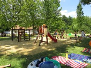 a park with a playground with people playing in it at Cottage by the Lake in Balatonudvari