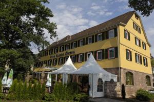 ein gelbes Gebäude mit einem Zelt davor in der Unterkunft Hotel Kloster Hirsau in Calw