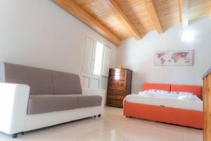 a living room with a couch and a bed at Casa vacanza “Grigio Perla” in Pachino