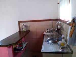een kleine keuken met een wastafel en een aanrecht bij Casa Estilo Kitnet in Campos do Jordão