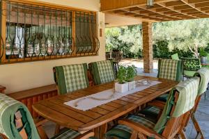 een houten tafel en stoelen op een patio bij Villa Umami in Mákri
