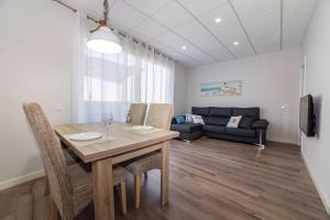 a dining room with a table and chairs and a couch at Apartamento Constancia in Sant Carles de la Ràpita
